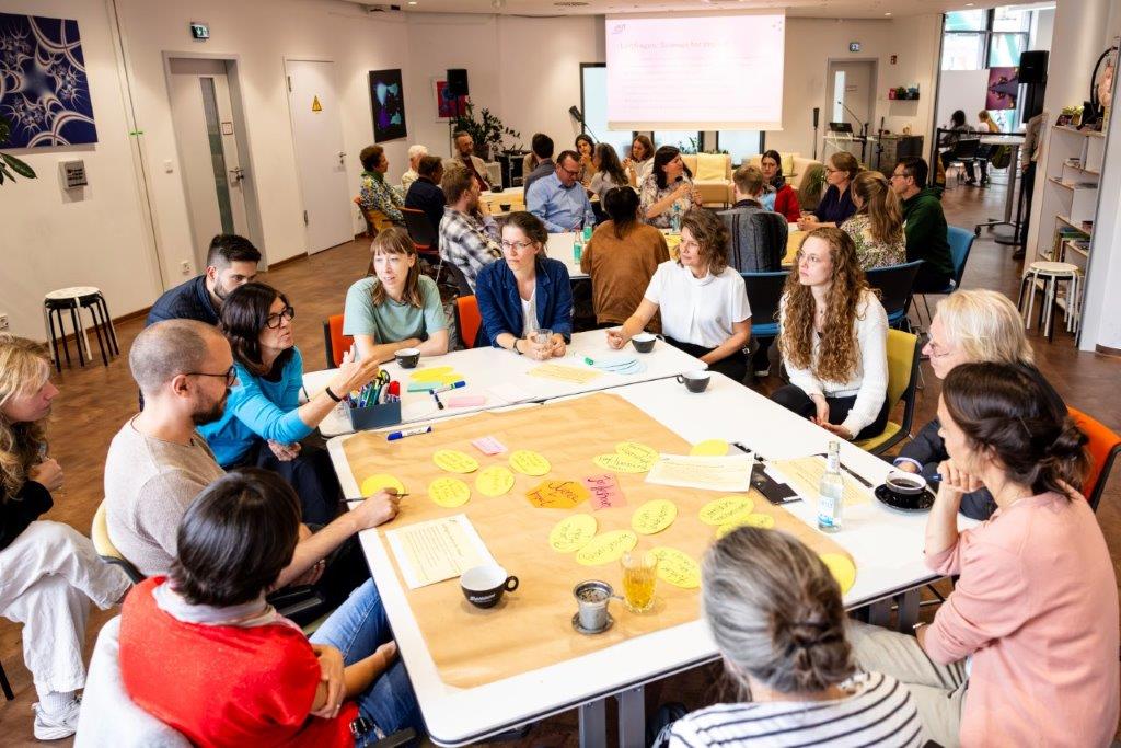 Menschengruppe an einem Tisch nimmt an einem Workshop teil